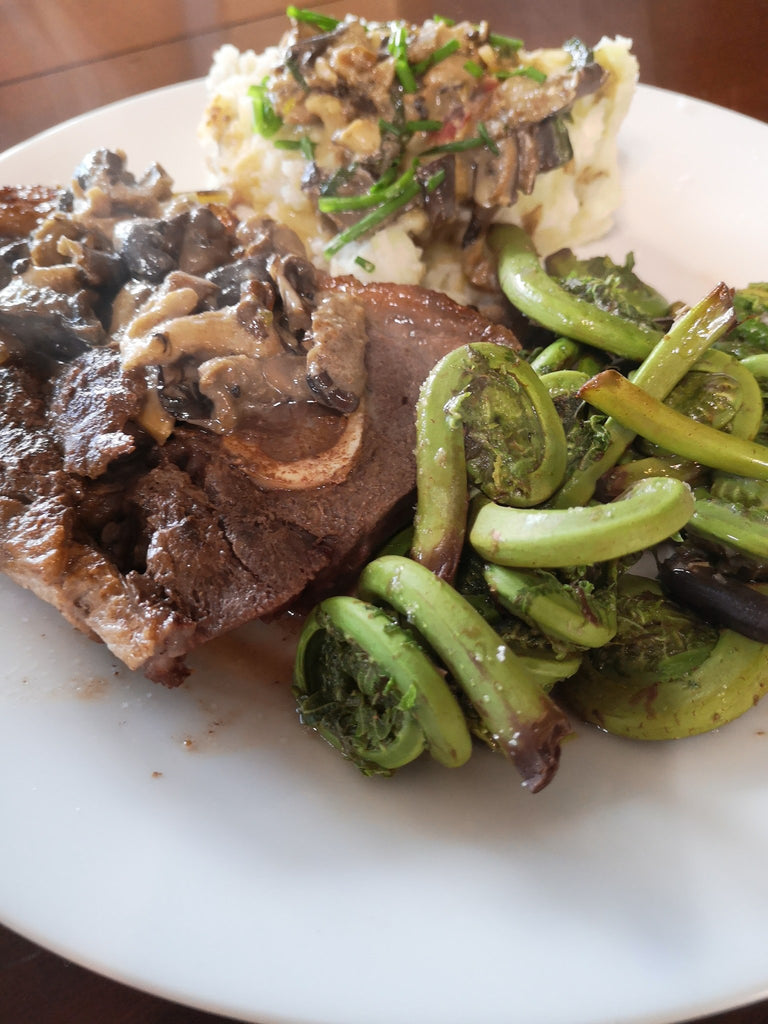 Local pork chops with mushroom medley gravy, steamed fiddleheads with lemon, and mashed potatoes with more mushroom medley gravy and chives!!